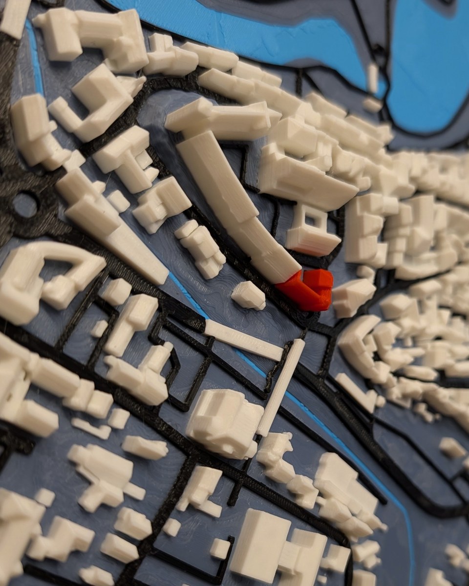 Farbiges 3D-Relief einer Altstadt mit Fluss auf einem geölten Eichenbrett mit Naturkante